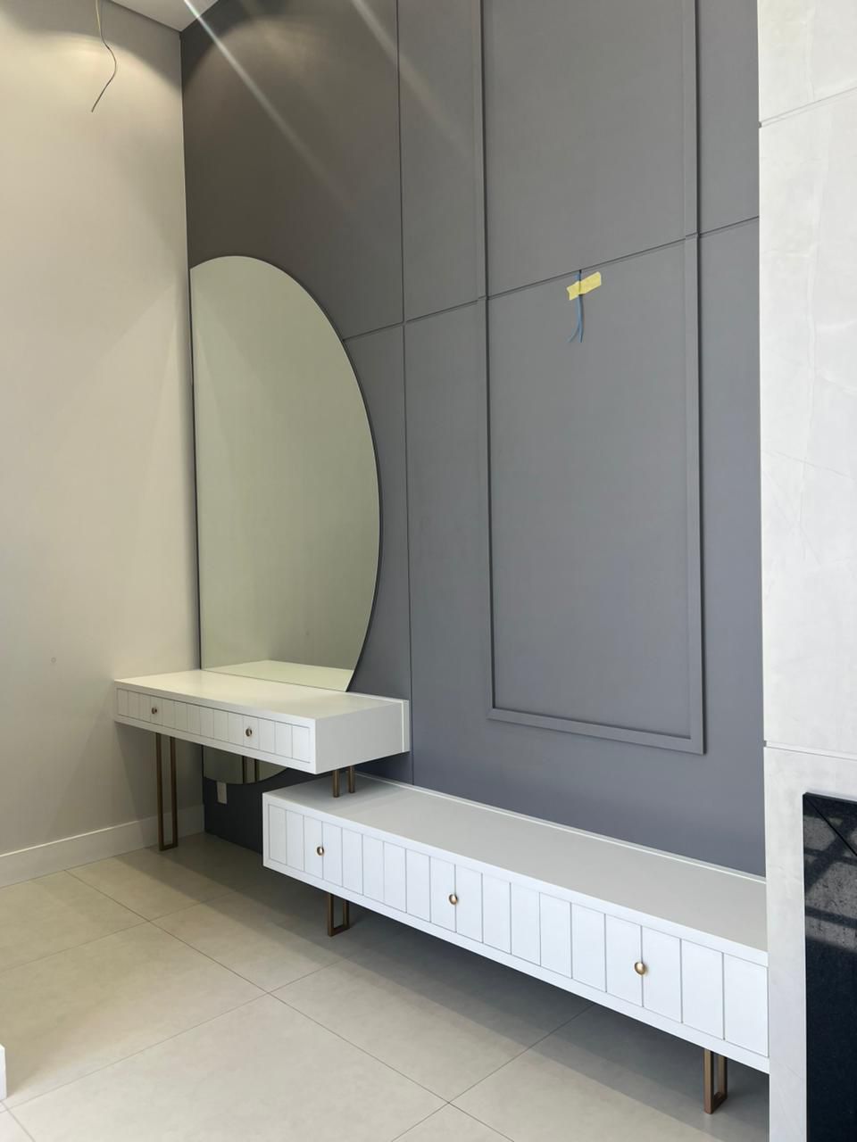 Hall com penteadeira flutuante branca, pés metálicos em bronze e espelho orgânico — projeto SCHREINER
