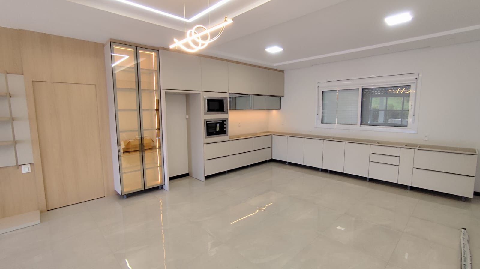 Cozinha integrada de alto padrão com marcenaria off-white e detalhes em carvalho — projeto SCHREINER